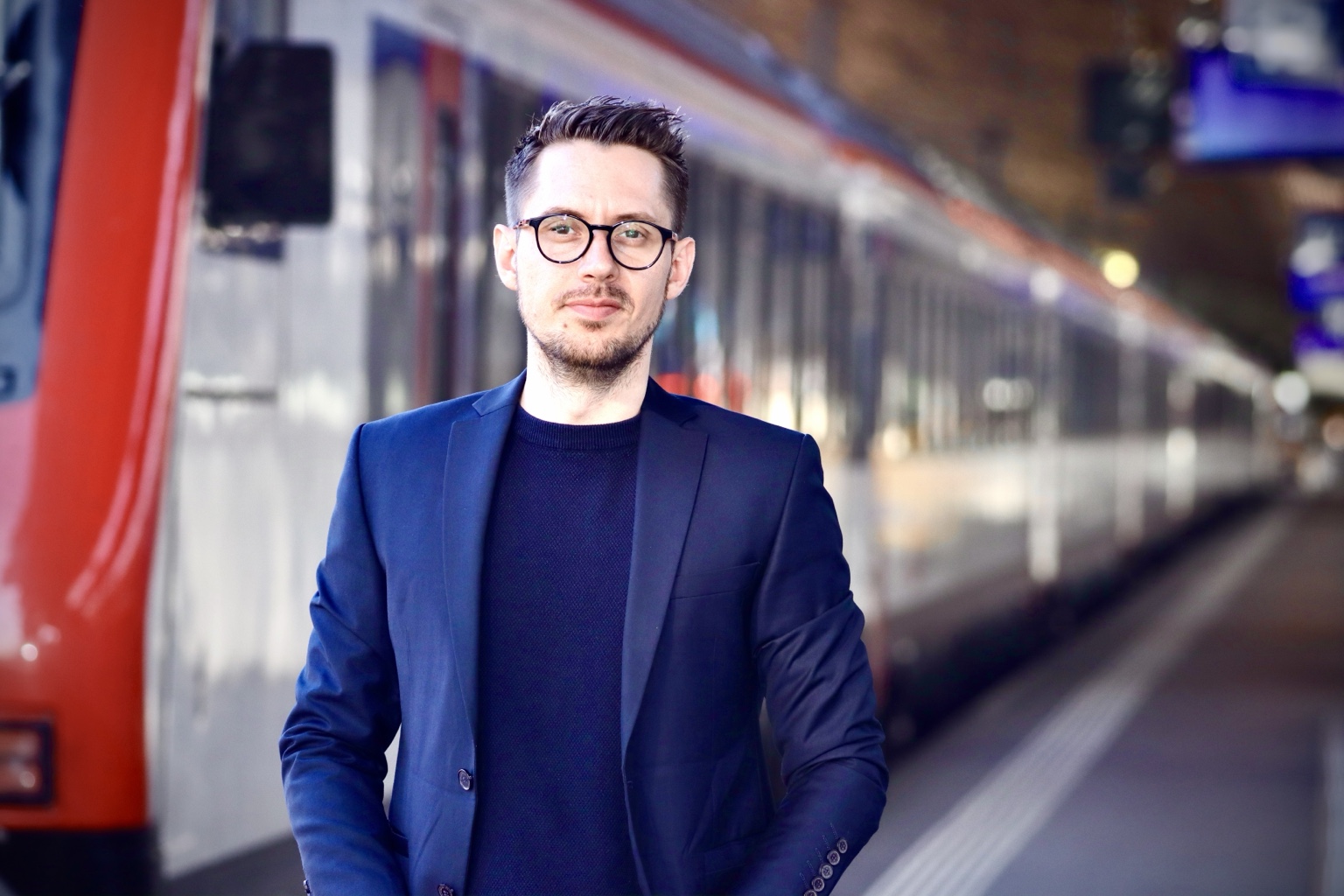 Philipp Kühne, mit Brille und dunkelblauem Sakko, blickt in die Kamera